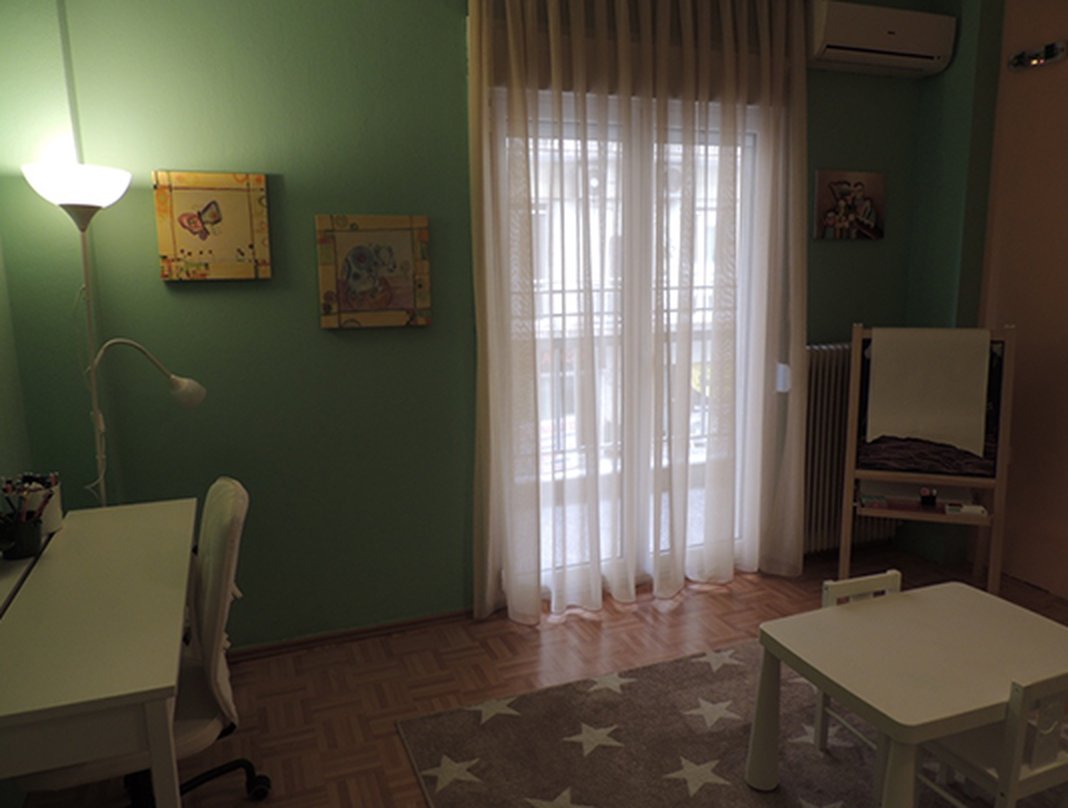 Ο χώρος για παιδιά με μικρό τραπέζι, καβαλέτο ζωγραφικής και φωτεινό παράθυρο